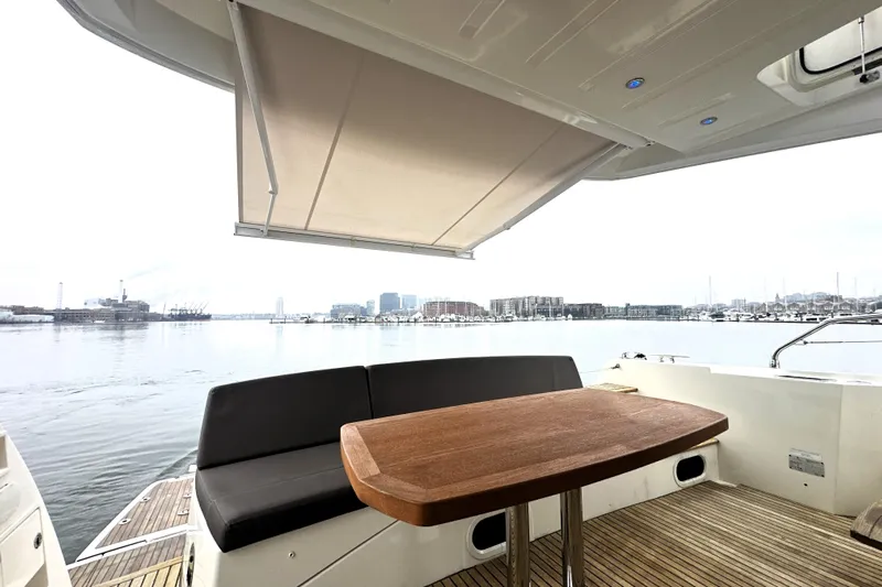Cyctrade Yacht Photos Pics Luxury yacht deck with seating and table, Prestige 500, 2017 model, overlooking a serene waterfront.