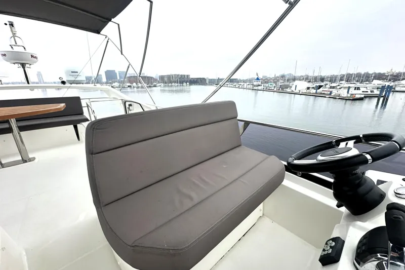 Cyctrade Yacht Photos Pics Flybridge of 2017 Prestige 500 yacht with helm and seating, overlooking marina.