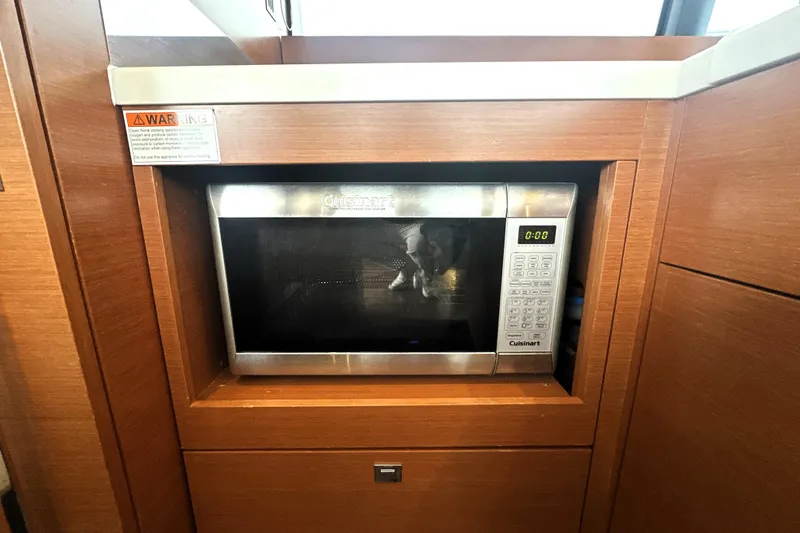 Cyctrade Yacht Photos Pics Built-in microwave in 2017 Prestige 500 yacht kitchen, featuring wood cabinetry.
