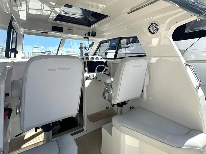 Lizzie Yacht Photos Pics Interior of 2020 Protector TARGA 380 boat with white seating and modern controls.