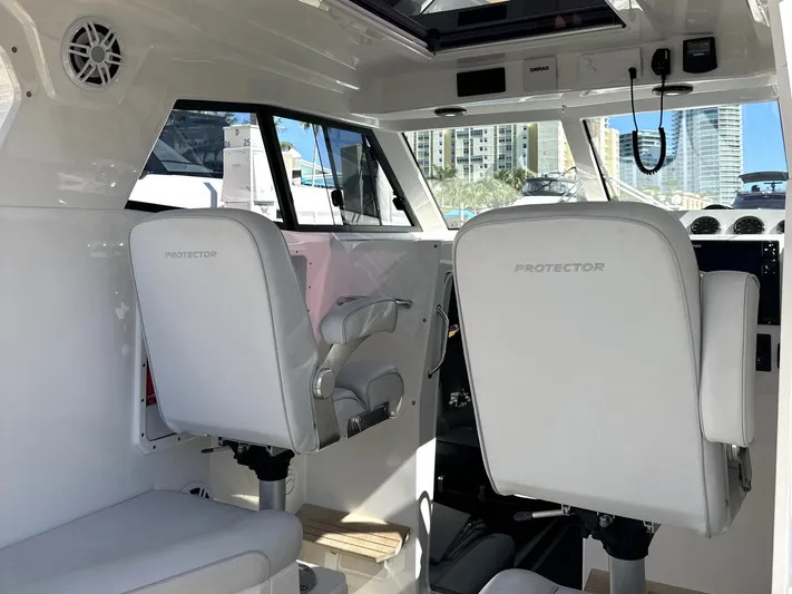 Lizzie Yacht Photos Pics Interior of 2020 Protector TARGA 380 boat with white seating and modern controls.