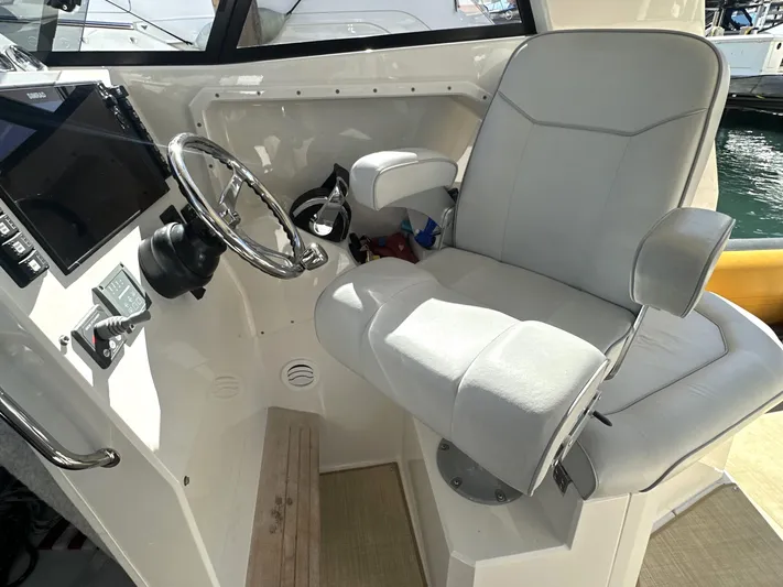 Lizzie Yacht Photos Pics Captain's chair and helm of 2020 Protector TARGA 380 boat, featuring steering wheel and controls.