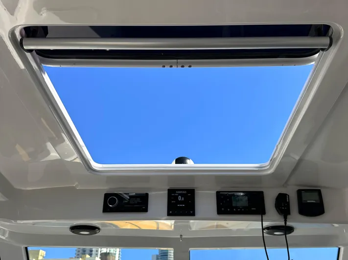 Lizzie Yacht Photos Pics Open sunroof view from 2020 Protector TARGA 380 boat, showcasing clear blue sky.