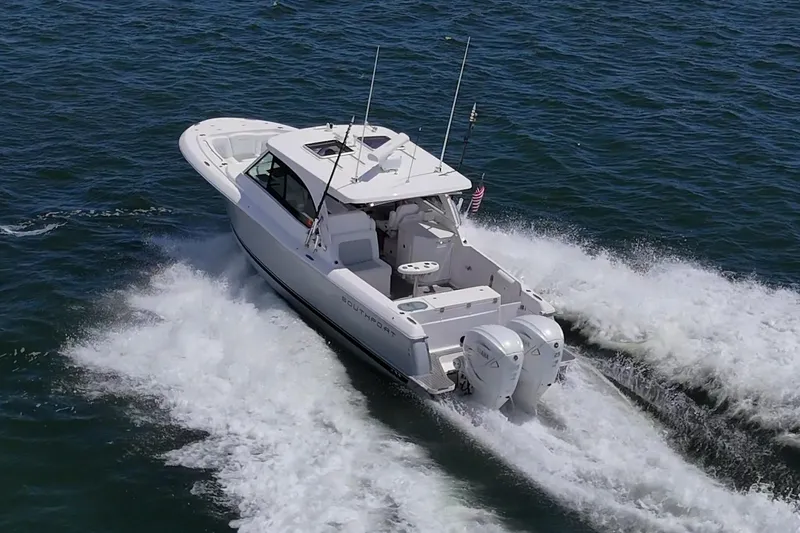  Yacht Photos Pics 2022 Southport 33 DC boat cruising on open water, rear view.