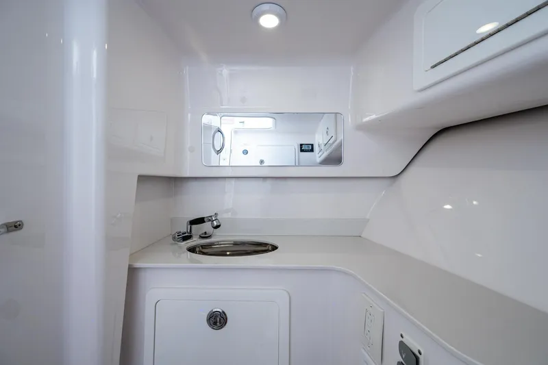  Yacht Photos Pics Modern bathroom interior in 2022 Southport 33 DC boat, featuring sleek sink and mirror.