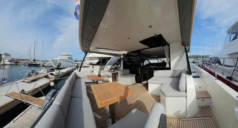 Diamond Si Yacht Photos Pics Luxurious 2024 Prestige M48 yacht interior with elegant seating and wooden table, docked at marina.