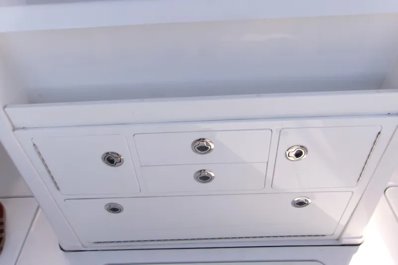  Yacht Photos Pics 2025 Sportsman Open 322 Center Console storage compartment with sleek white finish and metal handles.