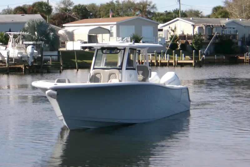  Yacht Photos Pics 2025 Sportsman Open 322 Center Console boat on calm water near docks.