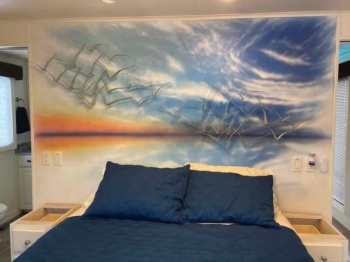 While It Lasts Yacht Photos Pics Bedroom with blue bedding, sunset mural, and metal bird wall art in a Thoroughbred 6516 model.
