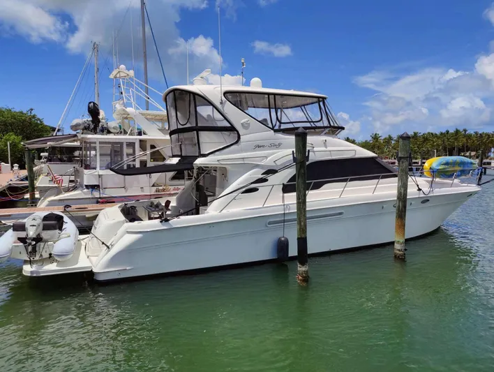 Wade N Winda Yacht Photos Pics 1999 Sea Ray 560 Sedan Bridge yacht docked in a marina under a clear blue sky.