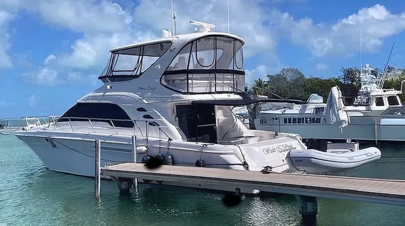 Wade N Winda Yacht Photos Pics 1999 Sea Ray 560 Sedan Bridge yacht docked in a marina under blue skies.