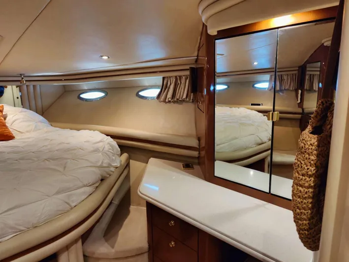 Wade N Winda Yacht Photos Pics Luxurious cabin interior of 1999 Sea Ray 560 Sedan Bridge yacht with bed and mirrored cabinet.