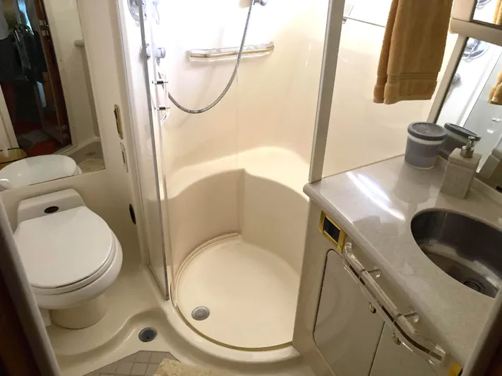 Wade N Winda Yacht Photos Pics Bathroom interior of 1999 Sea Ray 560 Sedan Bridge yacht, featuring shower, toilet, and sink.