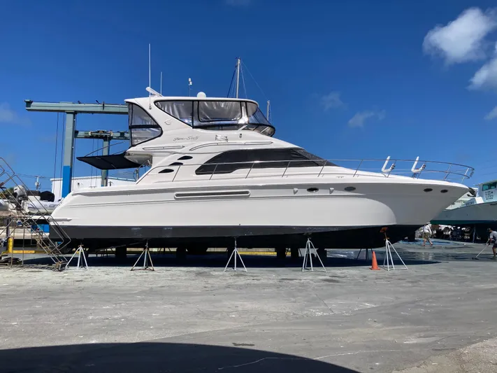 Wade N Winda Yacht Photos Pics 1999 Sea Ray 560 Sedan Bridge yacht on dry dock under clear blue sky.