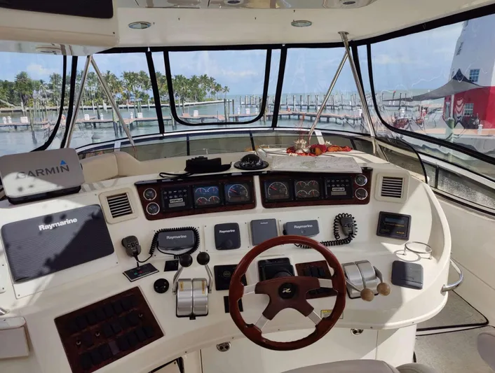 Wade N Winda Yacht Photos Pics 1999 Sea Ray 560 Sedan Bridge helm with navigation equipment and marina view.
