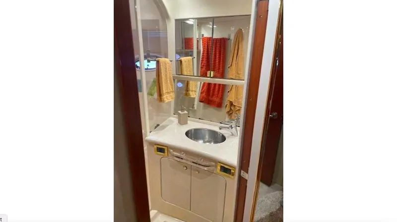 Wade N Winda Yacht Photos Pics Bathroom interior of 1999 Sea Ray 560 Sedan Bridge yacht with sink and colorful towels.