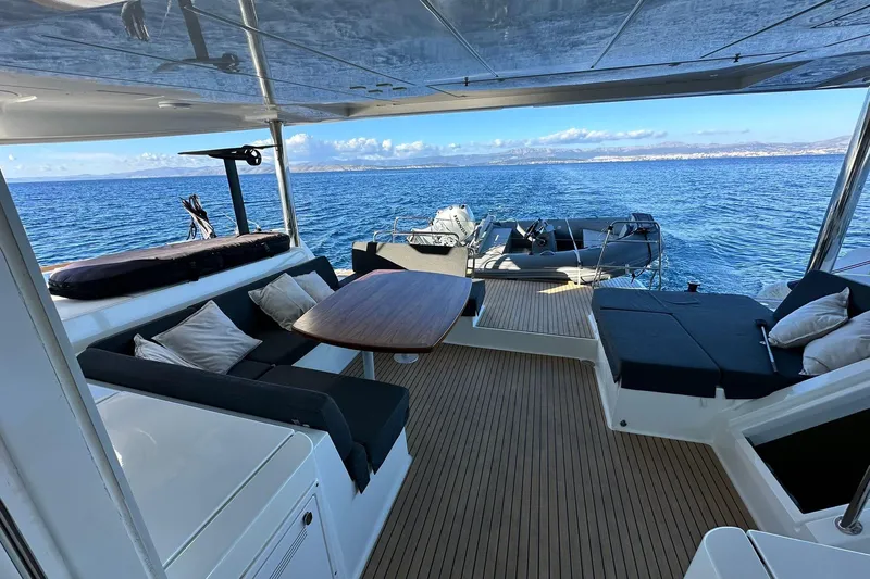  Yacht Photos Pics Luxurious Lagoon 52 F yacht deck with seating, table, and ocean view.