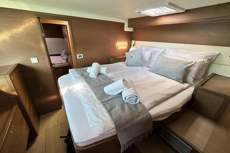  Yacht Photos Pics Luxurious cabin interior of 2019 Lagoon 52 F yacht with neatly arranged bed and towels.