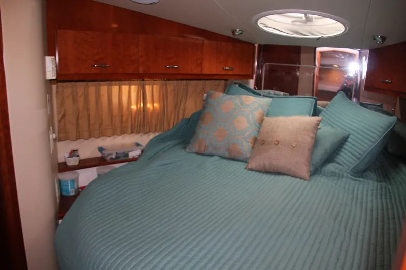  Yacht Photos Pics Luxurious bedroom interior of 2004 Carver 360 Sport Sedan with teal bedding and wooden cabinets.