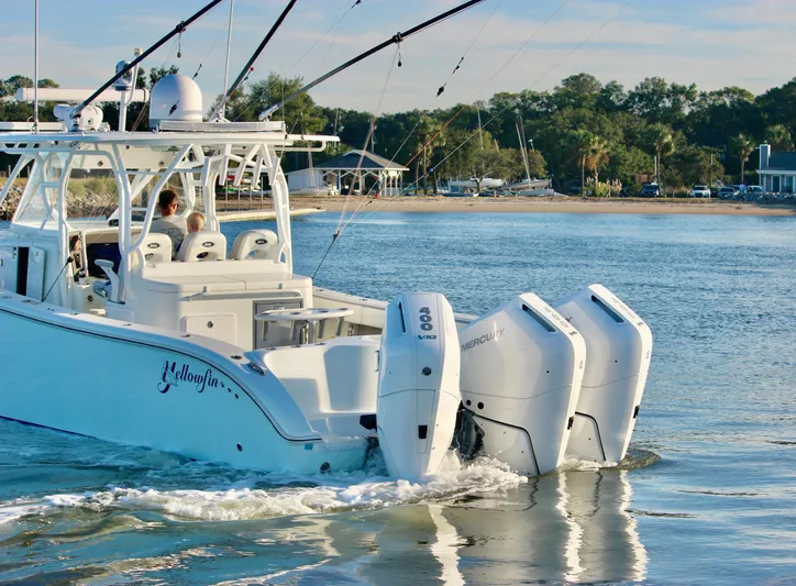  Yacht Photos Pics 2014 Yellowfin 42 boat with triple outboard engines cruising near the shore.