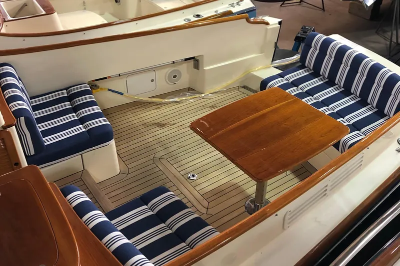 Standish Yacht Photos Pics 2017 Hinckley Picnic Boat 37 MKIII with striped seating and wooden table in the cockpit.