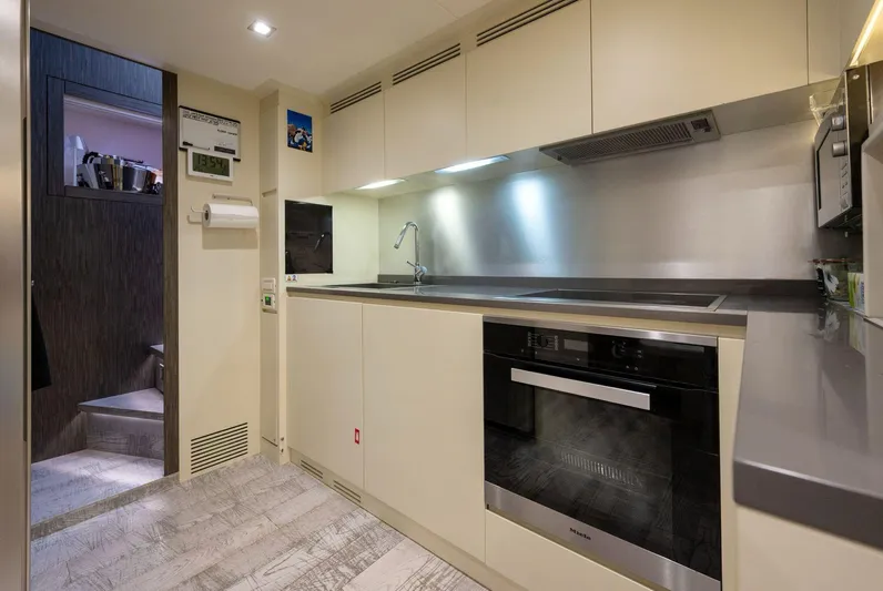  Yacht Photos Pics Modern kitchen interior on 2019 Pershing 82 yacht, featuring sleek cabinetry and appliances.