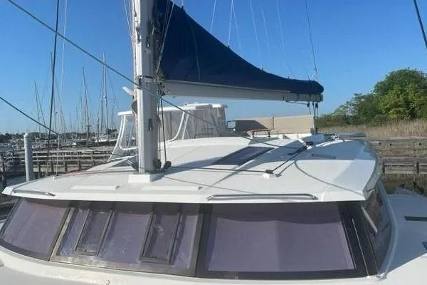 Endeavour Yacht Photos Pics 2020 Fountaine Pajot Saona 47 catamaran with blue sail, docked in marina.