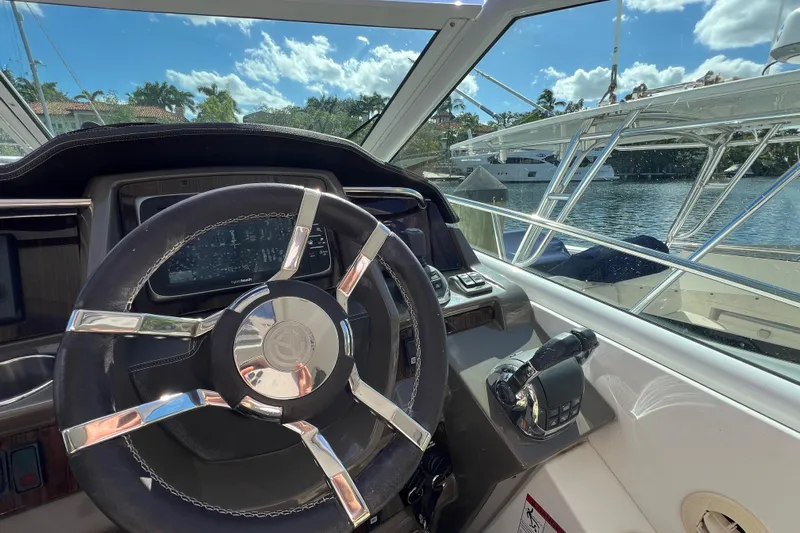 Life Of Leisure II Yacht Photos Pics Helm of 2013 Cruisers Yachts 380 Express with steering wheel and controls, docked by water.