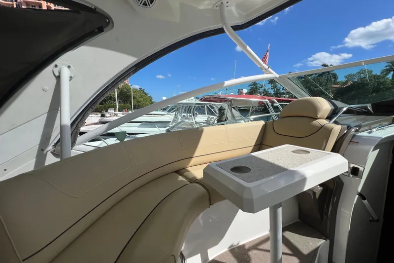 Life Of Leisure II Yacht Photos Pics 2013 Cruisers Yachts 380 Express interior with seating and table, docked under blue sky.