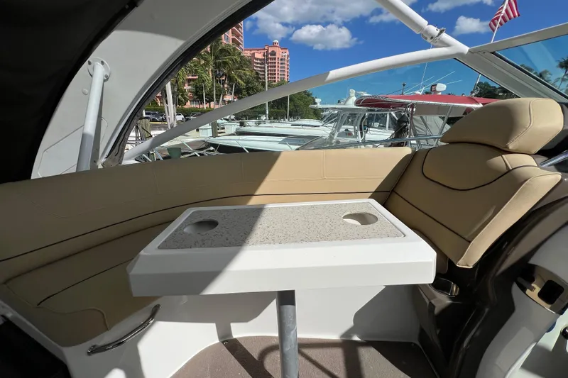 Life Of Leisure II Yacht Photos Pics Interior of 2013 Cruisers Yachts 380 Express with seating and table, docked under blue sky.