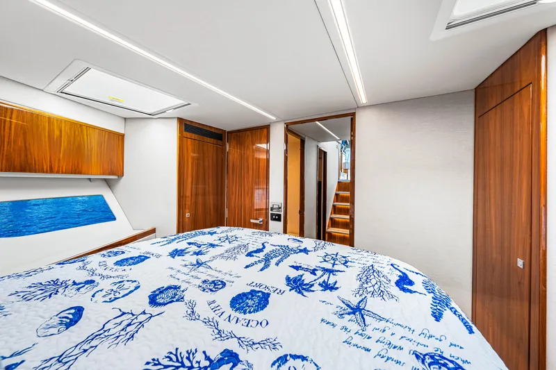  Yacht Photos Pics Luxurious interior of 2022 Riviera 505 SUV yacht with elegant wood finishes and nautical-themed bedding.