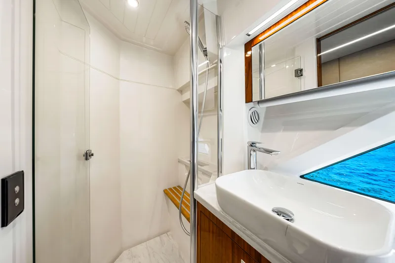  Yacht Photos Pics Luxurious bathroom interior of 2022 Riviera 505 SUV yacht, featuring modern sink and shower.