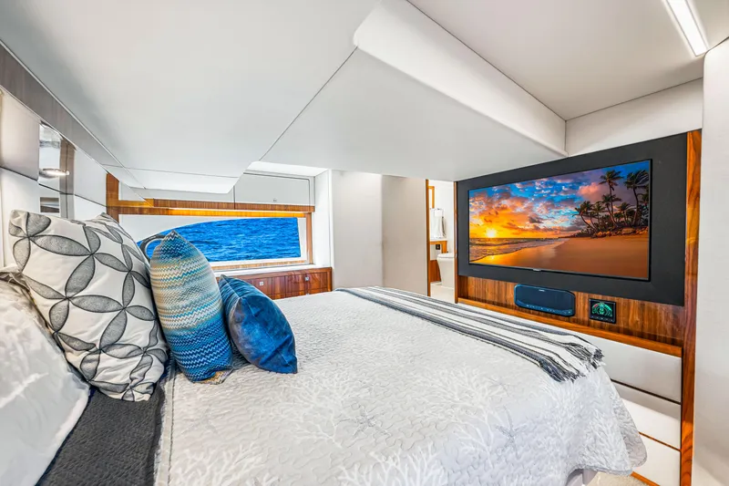  Yacht Photos Pics Luxurious bedroom interior of 2022 Riviera 505 SUV yacht with ocean view and TV.
