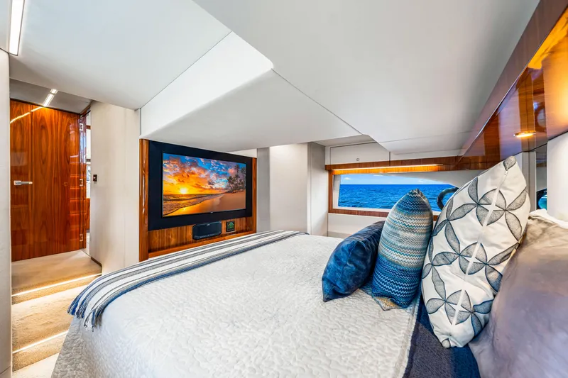  Yacht Photos Pics Luxurious bedroom interior of 2022 Riviera 505 SUV yacht with ocean view and modern decor.