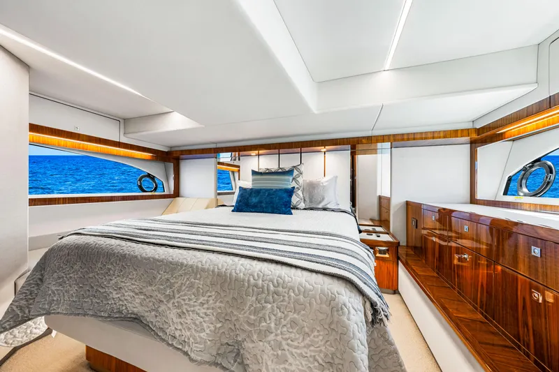  Yacht Photos Pics Luxurious bedroom interior of 2022 Riviera 505 SUV yacht with ocean view.