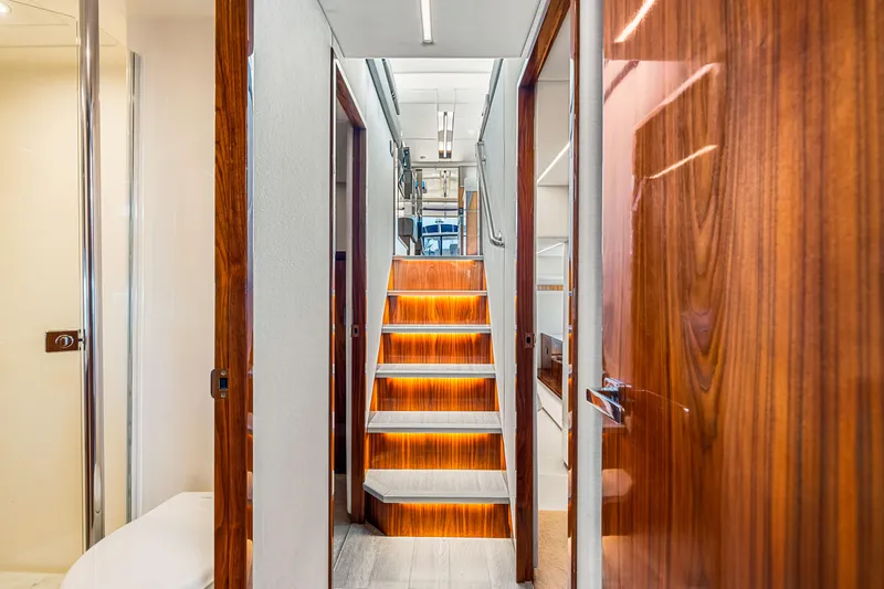  Yacht Photos Pics Interior of 2022 Riviera 505 SUV yacht with illuminated wooden stairs and modern design.