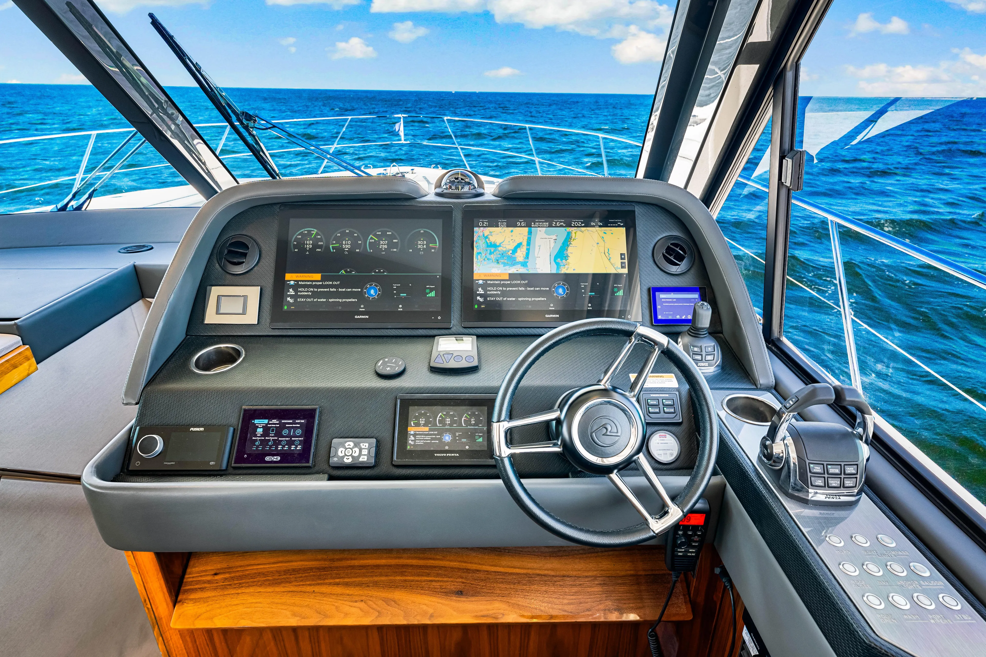  Yacht Photos Pics 2022 Riviera 505 SUV dashboard with navigation screens and steering wheel, overlooking the ocean.