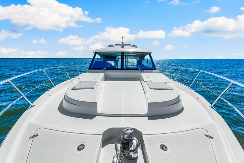  Yacht Photos Pics 2022 Riviera 505 SUV yacht cruising on open sea under blue sky.