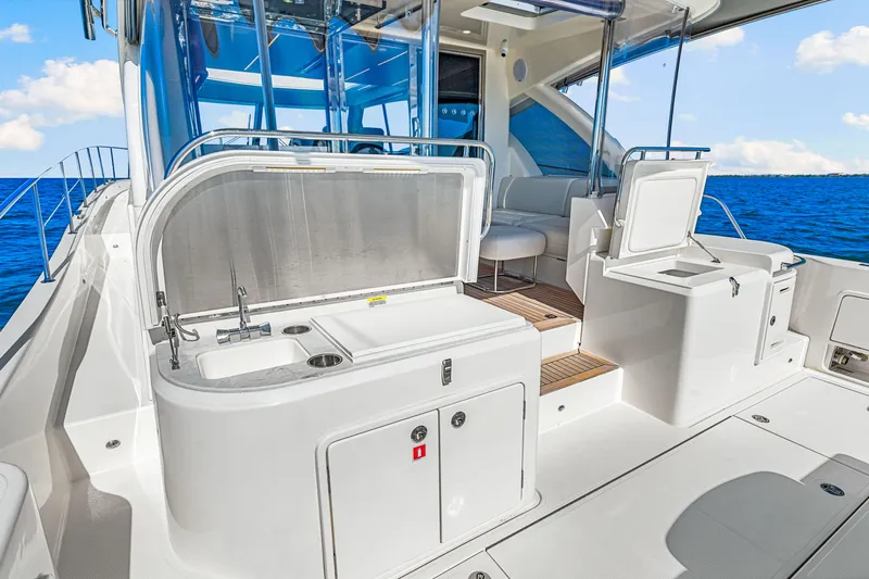  Yacht Photos Pics 2022 Riviera 505 SUV yacht interior with sleek kitchen and seating area, ocean view.