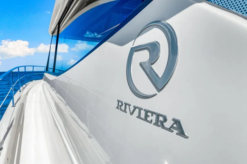  Yacht Photos Pics 2022 Riviera 505 SUV yacht with logo, cruising on a sunny day.