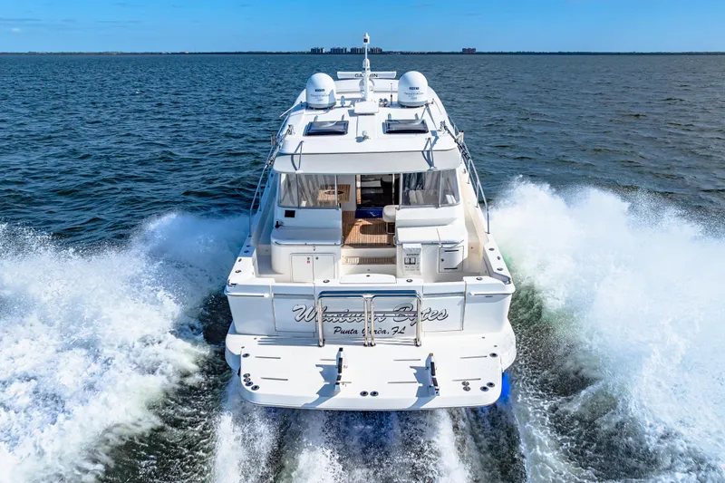  Yacht Photos Pics 2022 Riviera 505 SUV cruising on open water, rear view.