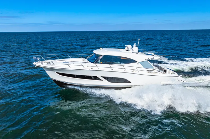  Yacht Photos Pics 2022 Riviera 505 SUV cruising on open sea under clear blue sky.