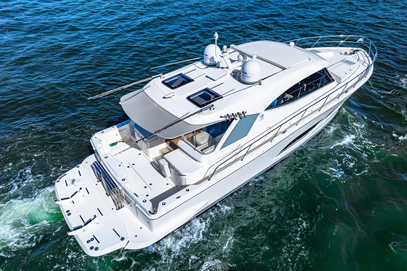  Yacht Photos Pics 2022 Riviera 505 SUV cruising on open water, showcasing sleek design and luxury features.