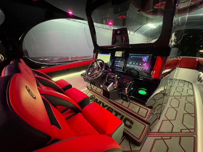  Yacht Photos Pics Interior of a 2018 Mystic Powerboats M4200, featuring red seats and advanced control panel.