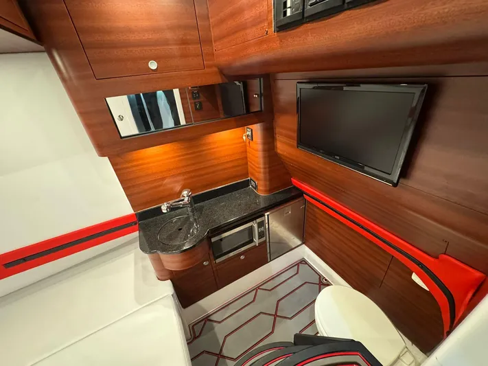  Yacht Photos Pics Luxurious interior of 2018 Mystic Powerboats M4200 with wood finish, TV, and kitchenette.