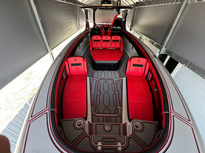  Yacht Photos Pics 2018 Mystic Powerboats M4200 interior with red seating and sleek design in a covered area.