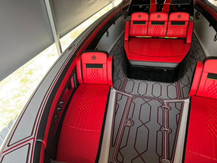  Yacht Photos Pics Luxurious 2018 Mystic Powerboats M4200 interior with red seating and geometric flooring design.