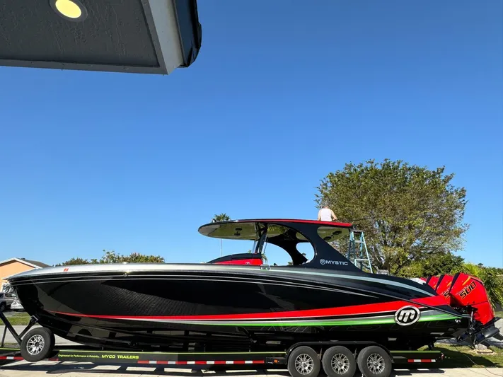  Yacht Photos Pics 2018 Mystic Powerboats M4200 on trailer, sleek black design with red and green accents.