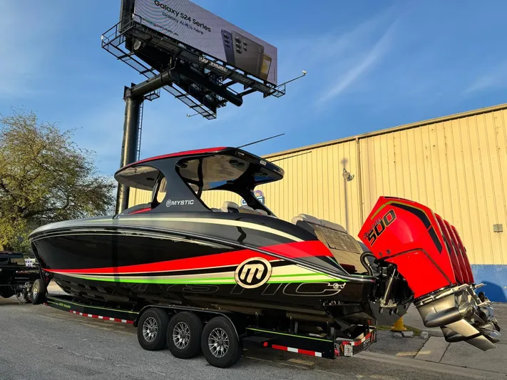  Yacht Photos Pics 2018 Mystic Powerboats M4200 with vibrant design on a trailer, under a billboard.