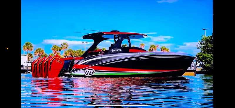  Yacht Photos Pics 2018 Mystic Powerboats M4200 on water, vibrant design, multiple engines, clear sky background.